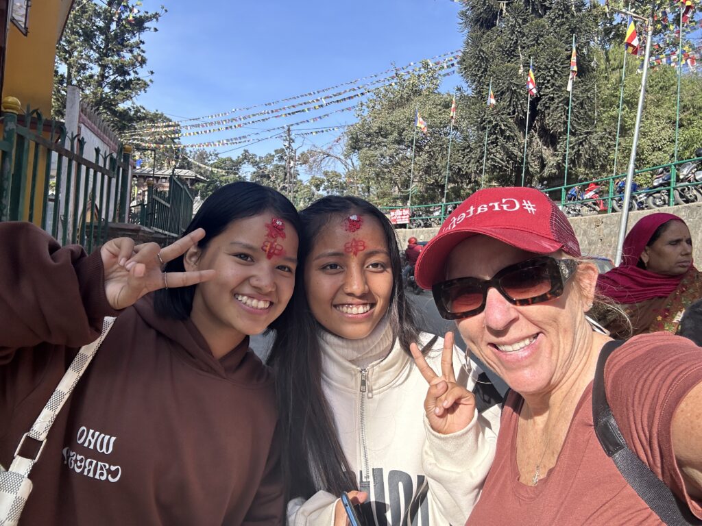 Group of smiling people taking a selfie together outdoors on a sunny day.