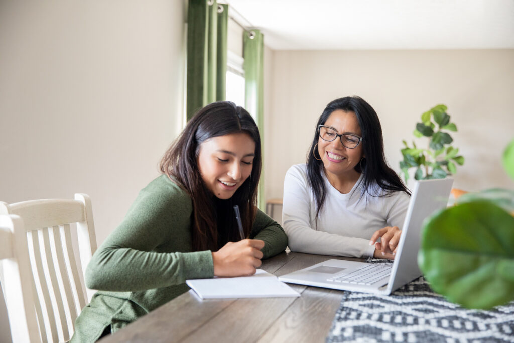 Student talking with an advisor across a desk in an office setting.