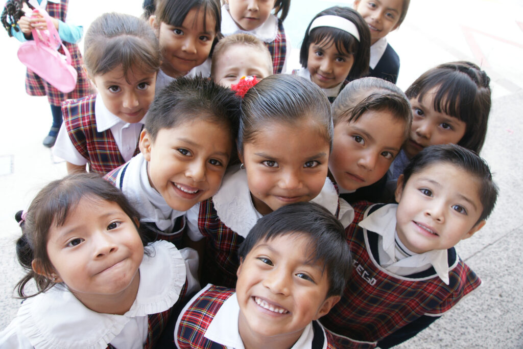Group of young children smiling together for a close-up photo.