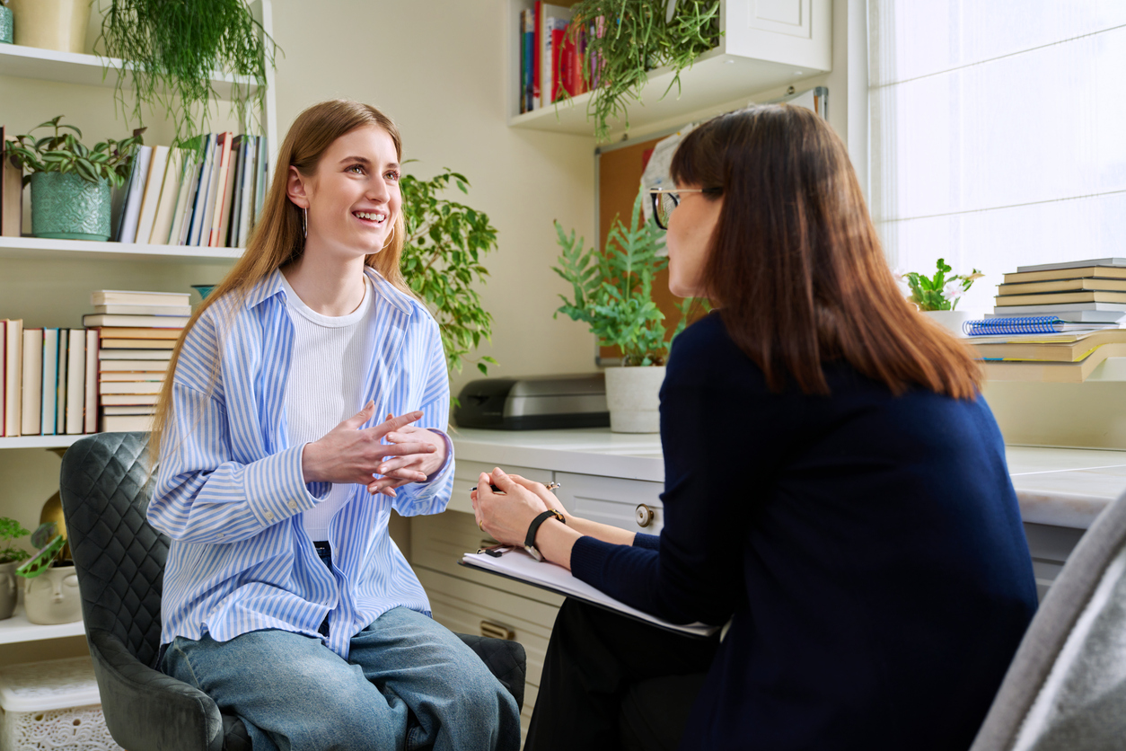 Student talking with a counselor during a one-on-one meeting in an office.