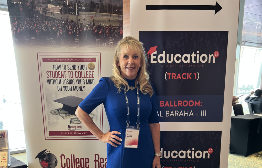 Woman standing beside an education display banner at an event booth.