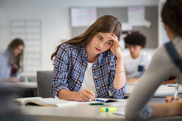 High school student studying and writing notes at desk, representing internship preparation and academic focus.