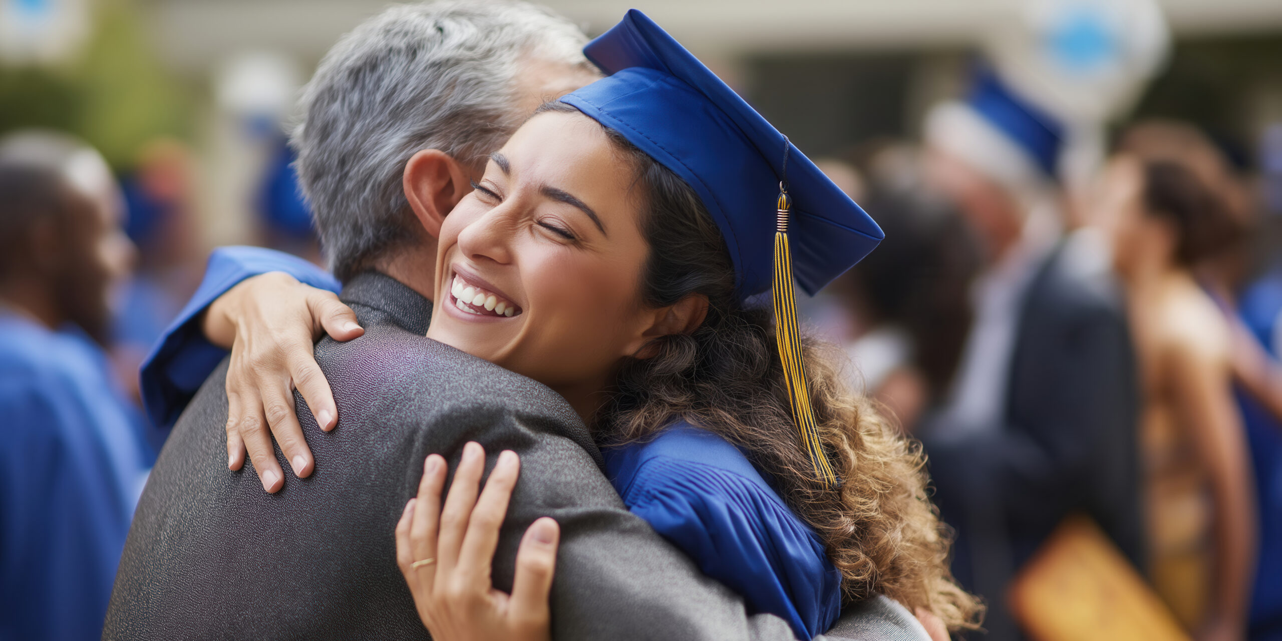 College graduate in a cap and gown embracing a family member during a graduation celebration.
