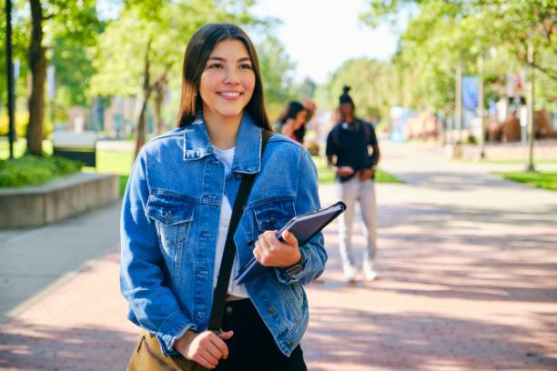 A young woman college student, standing on campus.