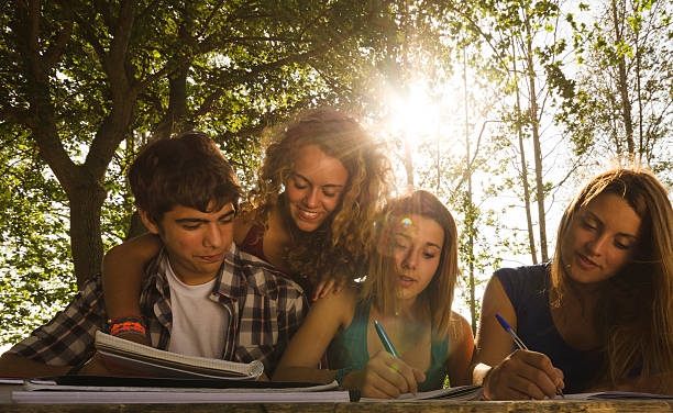 Happy college student friends studying